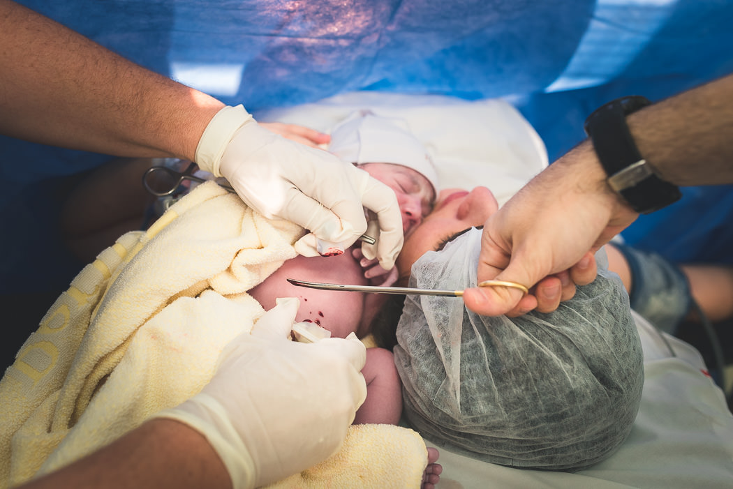 corte do cordao umbilical com bebe no colo - Bruno Montt Fotografia