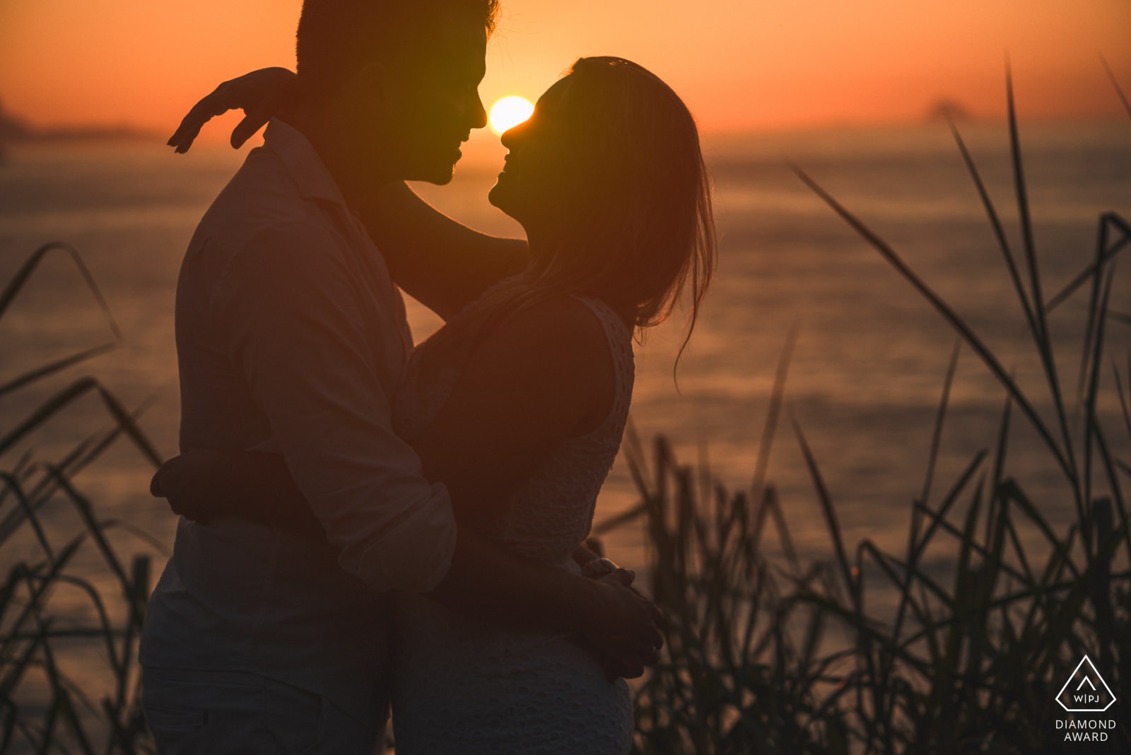 fotografia premiada de casal ao por do sol no grumari rio de janeiro